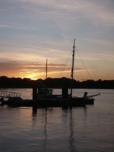 kleiner Kutter mit Sonnenuntergang im Hintergrund